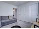 Comfortable bedroom featuring neutral tones, soft carpeting, and a gray sofa that offers additional seating or sleeping space at 8760 Ginkgo Loop, Parker, CO 80134