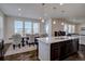 A well-lit kitchen with a large island, pendant lighting and an adjacent dining area with large windows at 8760 Ginkgo Loop, Parker, CO 80134