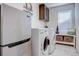 Functional laundry room features a stainless steel refrigerator, modern washer and dryer set, and storage solutions at 8760 Ginkgo Loop, Parker, CO 80134