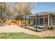 Backyard features gravel area, wood patio, shed, manicured lawn, mature trees and sunroom access at 851 Quitman St, Denver, CO 80204