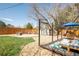 Spacious backyard with a well-maintained lawn, stone firepit, a shed, and patio area at 851 Quitman St, Denver, CO 80204