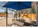 Well-kept backyard with mature trees, gravel area, shed, and covered patio with dining set at 851 Quitman St, Denver, CO 80204