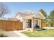 Quaint home with a covered porch, fenced yard and fresh green grass at 851 Quitman St, Denver, CO 80204