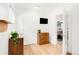 Hallway featuring a wooden dresser, a TV, and a view of the living room at 851 Quitman St, Denver, CO 80204