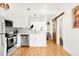Open kitchen with white cabinets, stainless steel appliances, and a decorative sliding wood door at 851 Quitman St, Denver, CO 80204