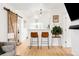 Open living room with hardwood floors, bar seating, and rustic sliding barn door at 851 Quitman St, Denver, CO 80204