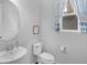 Half bathroom featuring a single sink vanity with a modern faucet and blue patterned window curtains at 887 Sundance Ln, Erie, CO 80516