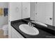 Bathroom vanity with white sink, black countertop, and neutral colored walls at 887 Sundance Ln, Erie, CO 80516