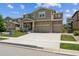 Charming two-story home featuring a stone and siding exterior, attached two-car garage, and manicured front yard at 887 Sundance Ln, Erie, CO 80516