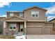 Charming two-story home featuring stone accents, neutral siding, and a two-car garage with a well-manicured front yard at 887 Sundance Ln, Erie, CO 80516