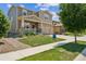 Attractive two-story home featuring stone accents, a welcoming front porch, and a well-cared-for lawn at 887 Sundance Ln, Erie, CO 80516