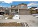 Attractive two-story home with a stone facade and complementary siding, featuring a spacious driveway and an inviting front porch at 887 Sundance Ln, Erie, CO 80516