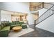 Bright living room with a high ceiling, a large sofa, hardwood floors and a staircase at 887 Sundance Ln, Erie, CO 80516