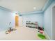 Bright playroom with light blue walls, a white storage unit filled with toys, and a white carpeted floor at 887 Sundance Ln, Erie, CO 80516