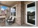 Inviting covered porch with stacked stone columns and seating area with views of the street at 887 Sundance Ln, Erie, CO 80516