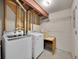 Unfinished basement laundry room with machines and a wooden work table at 9200 E Cherry Creek South Dr # 29, Denver, CO 80231