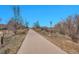 Paved community walking path is bordered by natural grasses and shrubs with an occasional tree at 9200 E Cherry Creek South Dr # 29, Denver, CO 80231