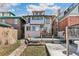Exterior rear elevation of a two-story home with gray siding, a wood deck, and a small backyard at 1451 N Gilpin St, Denver, CO 80218