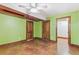 Bedroom with green walls, concrete floors, ceiling fan and two wood paneled doors at 1451 N Gilpin St, Denver, CO 80218
