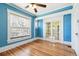 Bright blue living room with hardwood floors, large window, and view into another room at 1451 N Gilpin St, Denver, CO 80218
