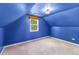 A blue painted attic offers a unique living space with a window and carpeted floor at 2535 S Julian St, Denver, CO 80219