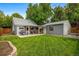 Expansive backyard with lush lawn, patio, and detached garage, perfect for outdoor living at 2535 S Julian St, Denver, CO 80219