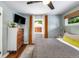 Comfortable bedroom featuring wood floors, ceiling fan, stylish curtains, and natural light at 2535 S Julian St, Denver, CO 80219