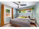 Cozy bedroom with a ceiling fan, green walls, wood floors, and two windows at 2535 S Julian St, Denver, CO 80219