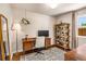 Inviting home office features a wooden desk, decorative rug, and hanging plant accenting the bright space at 2535 S Julian St, Denver, CO 80219