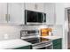 Modern kitchen with stainless steel stove, subway tile backsplash, and quartz countertops at 2535 S Julian St, Denver, CO 80219