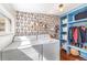 Functional laundry room with washer, dryer, built-in shelving, and stylish wallpaper at 2535 S Julian St, Denver, CO 80219