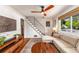 Cozy living room with hardwood floors, a sectional sofa, modern ceiling fan and staircase at 2535 S Julian St, Denver, CO 80219