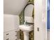 Charming powder room with pedestal sink, patterned wallpaper, and vintage charm at 2535 S Julian St, Denver, CO 80219