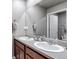 Bathroom featuring double sinks, a large mirror, and wood cabinets at 5789 Echo Park Cir, Castle Rock, CO 80104