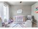 Bright Bedroom featuring a white crib, soft armchair, and window at 5789 Echo Park Cir, Castle Rock, CO 80104
