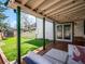 Covered back porch with wooden deck and outdoor furniture overlooking artificial grass lawn at 2733 S Riverview Dr, Idledale, CO 80453