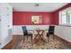 Charming dining area with red accent wall, table for two, and decorative rug at 2733 S Riverview Dr, Idledale, CO 80453