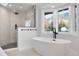 Luxurious bathroom with a soaking tub, a walk-in shower, and large windows at 245 Fair Pl, Boulder, CO 80302