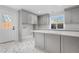 Bright laundry room with gray cabinetry, marble flooring, and a center island at 245 Fair Pl, Boulder, CO 80302