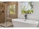 Relaxing bathroom featuring a freestanding tub under a window, accompanied by a separate glass-enclosed shower at 2844 Quitman St, Denver, CO 80212