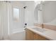 Modern bathroom features a shower-tub combo, white tile, and a wood vanity with a white countertop at 2844 Quitman St, Denver, CO 80212