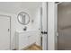 Bathroom with a modern white vanity, round mirror, and a glass-enclosed shower at 2844 Quitman St, Denver, CO 80212