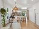 Open dining area features a modern light fixture and seamlessly connects to the stylish kitchen with bar seating at 2844 Quitman St, Denver, CO 80212