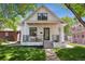 Inviting two-story white home featuring a cozy front porch, complemented by a well-kept yard and a brick structure at 2844 Quitman St, Denver, CO 80212