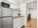Efficient kitchenette with butcher block countertop, stainless steel fridge, and open shelving at 2844 Quitman St, Denver, CO 80212