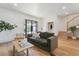 Spacious living room with a large comfortable sofa, hardwood floors, and access to the staircase at 2844 Quitman St, Denver, CO 80212