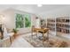 Bright home office with built-in bookshelves and a large window offering natural light and views of lush greenery at 2844 Quitman St, Denver, CO 80212