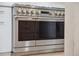 Monogram stainless steel range with gold knobs and dark glass doors, set in a white kitchen at 2844 Quitman St, Denver, CO 80212