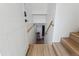 Bright staircase leads downstairs with wood treads and handrail contrasting against the white walls at 2844 Quitman St, Denver, CO 80212