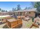 Brick home with a spacious backyard, featuring raised garden beds and a covered patio at 1744 S Leyden St, Denver, CO 80224